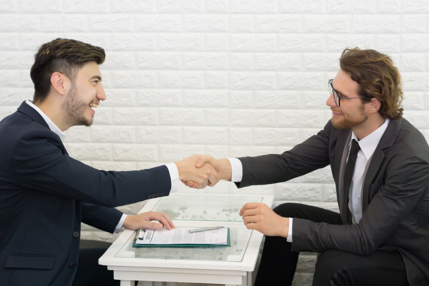 Two professionals shaking hands across a table